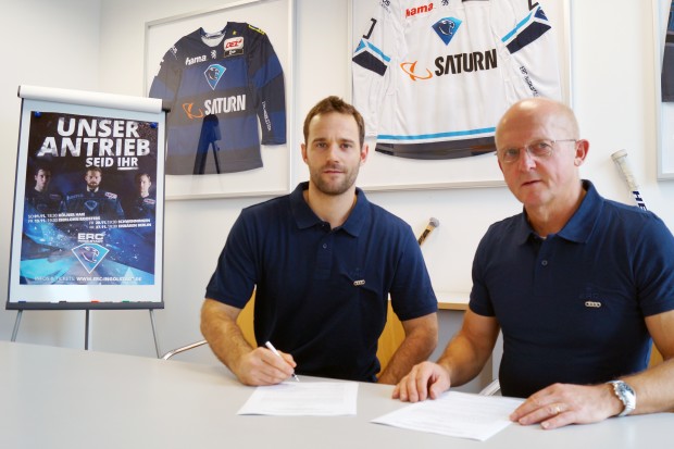 Dustin Friesen (left) signing his contract next to director sports Jiri Ehrenberger.