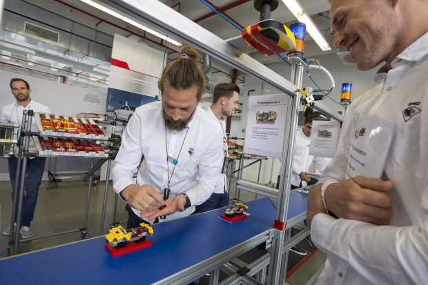Torhüter Timo Pielmeier baut unter den prüfenden Augen von Benedikt Schopper an seinem Lego-Audi. Foto: Stefan Sauer / Audi
