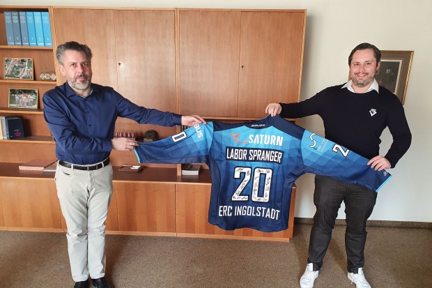 Ein Dankeschön für die große Hilfe: Nicholas Rausch (re.) überreicht Dr. Steffen Spranger ein Trikot mit den Unterschriften des Teams.